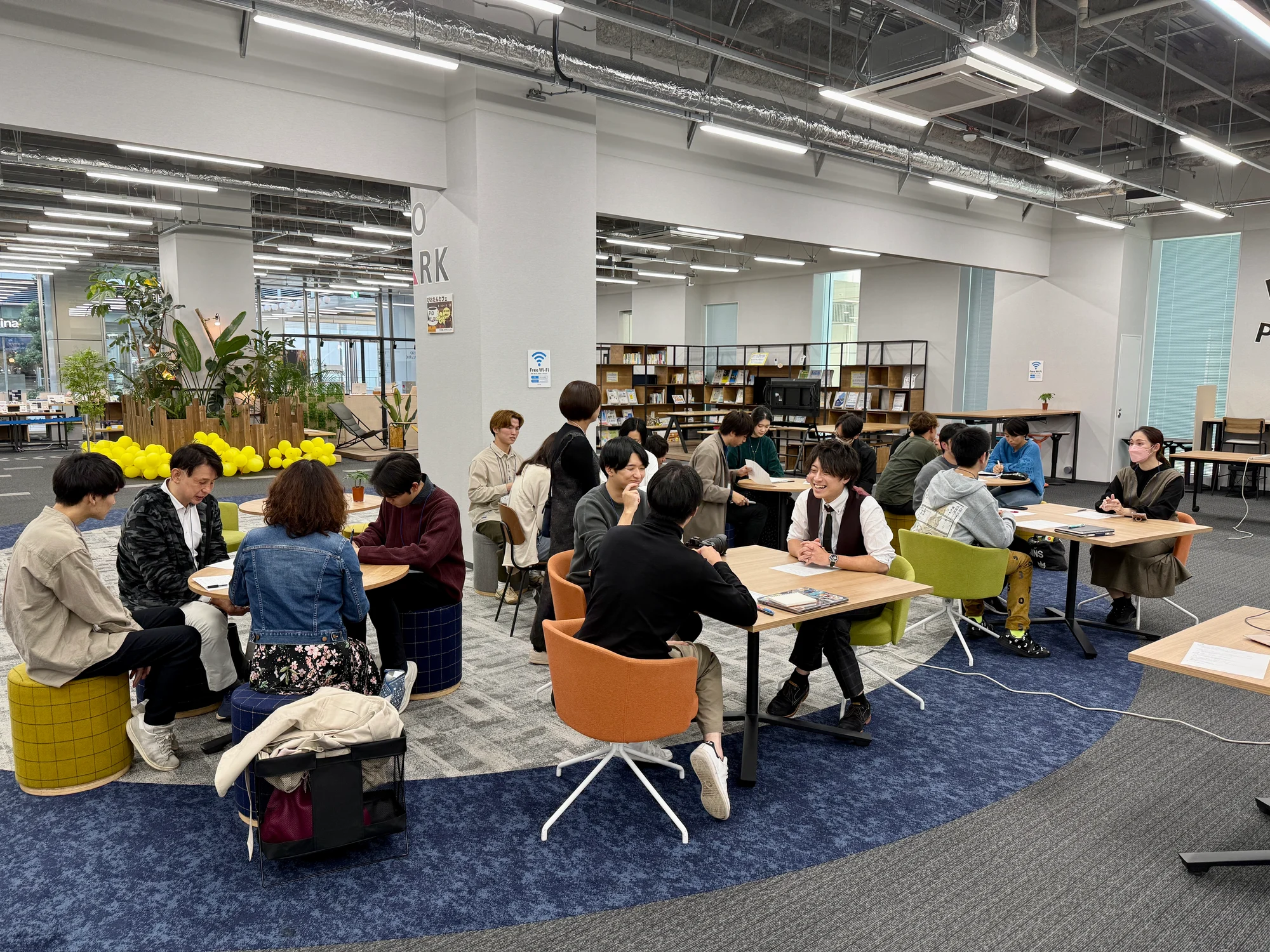 広い会場で複数のグループが対話している様子